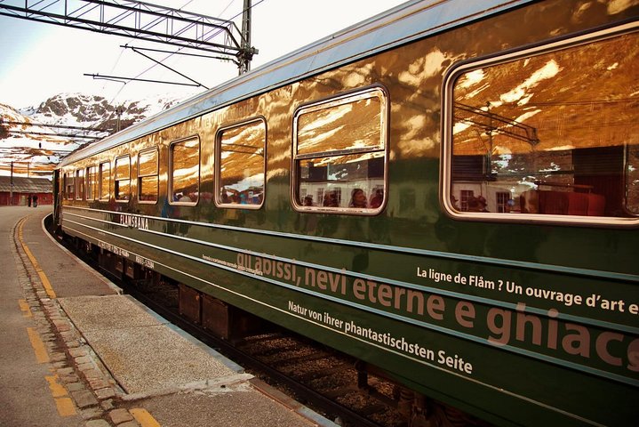 The green Flåm Railway train climbing the steep mountainside in Flåm valley - Jandis Tours