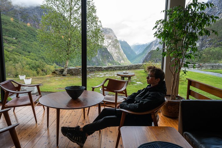 Stalheim Hotel View Nærøydalen A tourist relaxing on the terrace of Stalheim Hotel, enjoying the breathtaking panoramic view of the UNESCO World Heritage site Nærøydalen valley on a private tour with Jandis Fjord Tours.