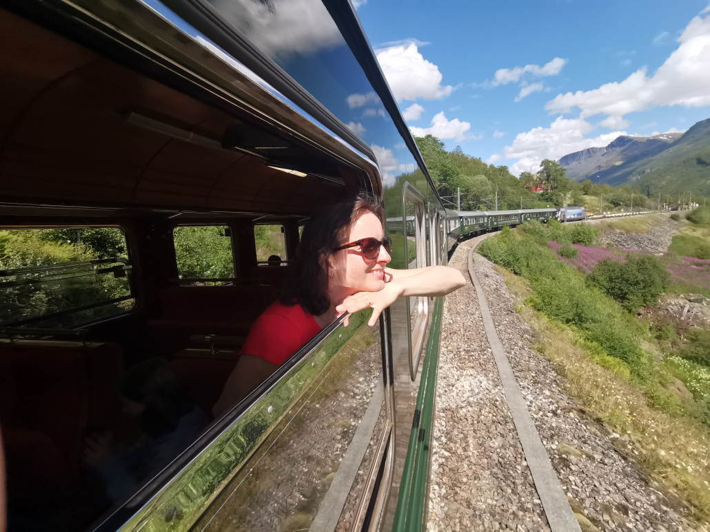 Woman looking at the country side valley view from Flåm Railway train - Jandis Tours